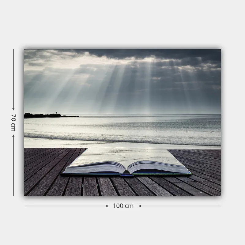 Lærred 70x100 cm - Åben bog liggende på en træmole ved havet, omgivet af bløde lysstråler fra en overskyet himmel - Grå / Blå / Hvid - Boligtilbehør - Billeder & kunst - Billeder på lærred