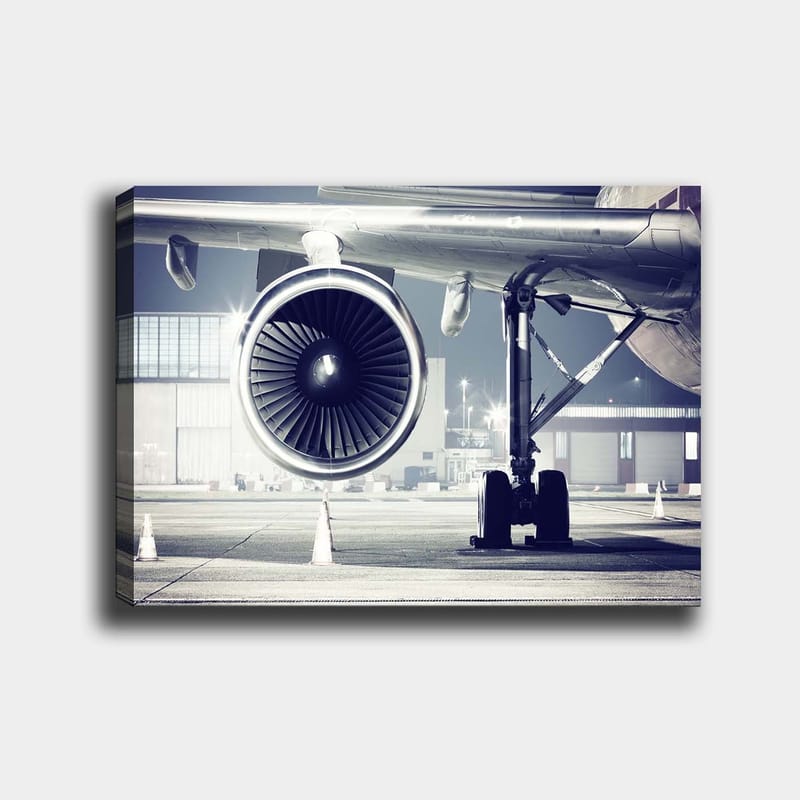 Lærred 70x100 cm - Detaljeret visning af en flymotor og dens understel i en lufthavn, Grå / Sort / Sølv