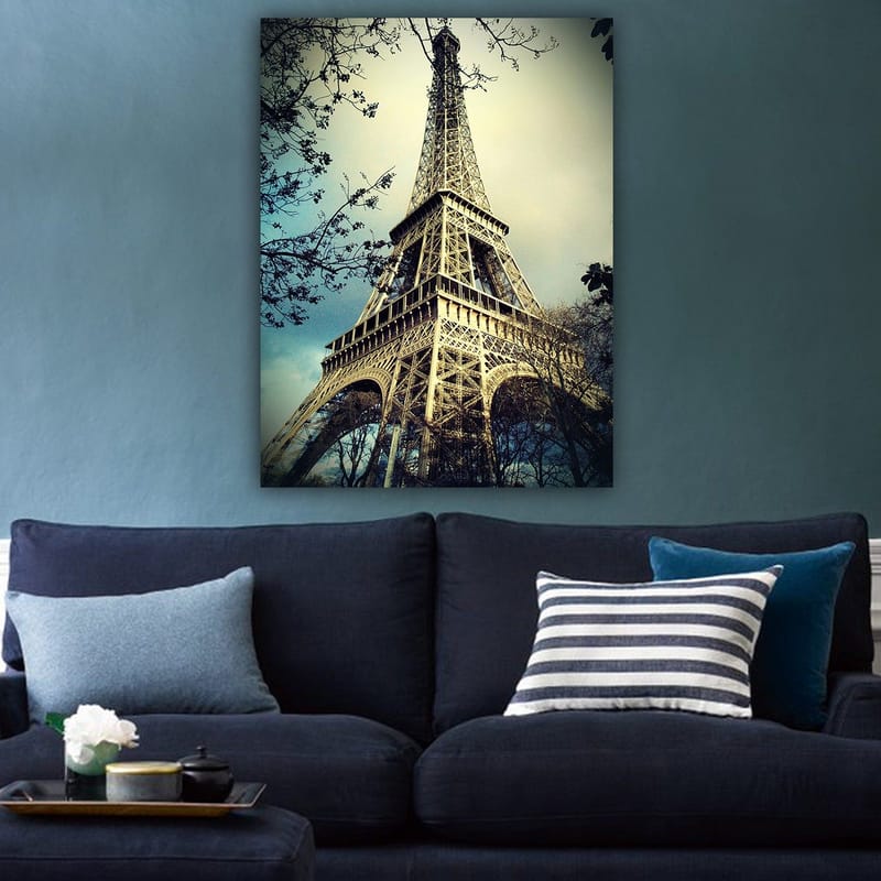 Lærred 70x100 cm - Eiffeltårnet i Paris, fotograferet fra en lav vinkel med omgivende trægrene - Grå / Beige / Blå - Boligtilbehør - Billeder & kunst - Billeder på lærred