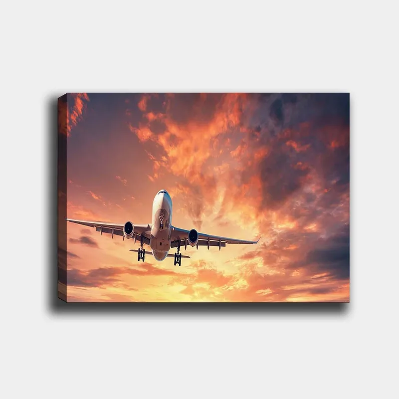 Lærred 70x100 cm - Et fly lander mod en dramatisk solnedgang med farverige skyer, Orange / Lilla / Blå