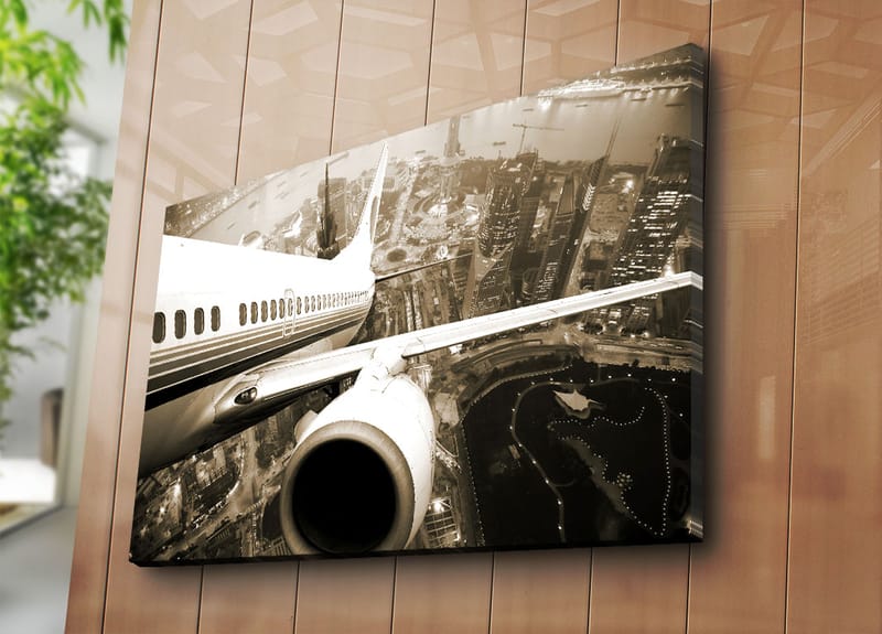 Lærred 70x100 cm - Et fly svæver over en by i tusmørke - Sort / Hvid / Grå - Boligtilbehør - Billeder & kunst - Billeder på lærred