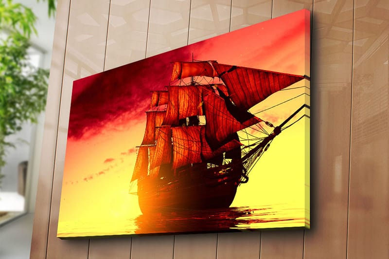 Lærred 70x100 cm - Et majestætisk sejlskib med røde sejl, der navigerer gennem en gylden solnedgang - Rød / Orange / Gul - Boligtilbehør - Billeder & kunst - Billeder på lærred