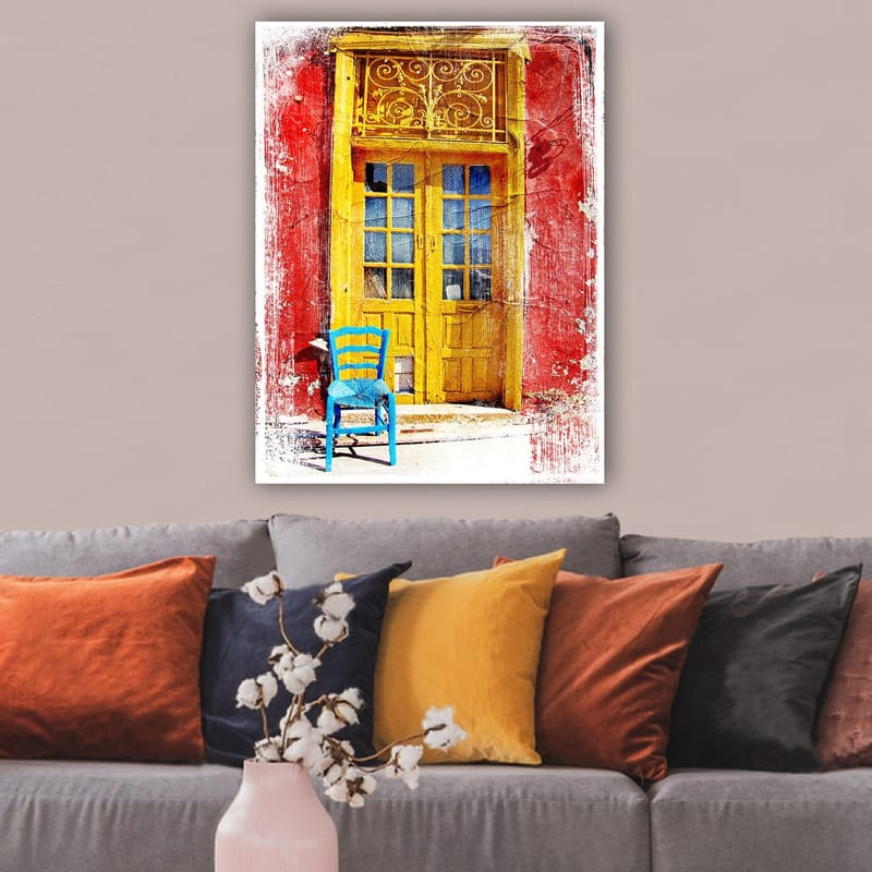 Lærred 70x100 cm - Farverig dør med en blå stol foran på en rød væg - Gul / Rød / Blå - Boligtilbehør - Billeder & kunst - Billeder på lærred