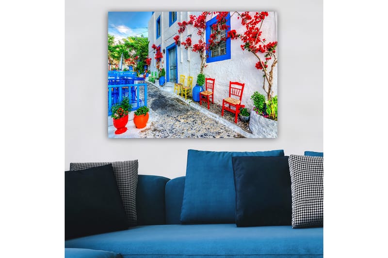 Lærred 70x100 cm - Farverig gade med blomster og stole i forskellige farver, der skaber en livlig atmosfære - Blå / Rød / Grøn - Boligtilbehør - Billeder & kunst - Billeder på lærred