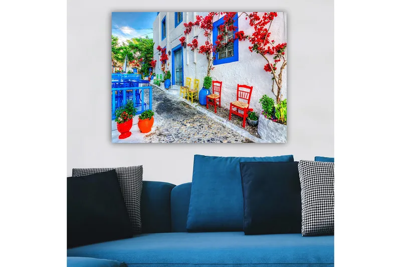 Lærred 70x100 cm - Farverig gade med blomster og stole i forskellige farver, der skaber en livlig atmosfære - Blå / Rød / Grøn - Boligtilbehør - Billeder & kunst - Billeder på lærred