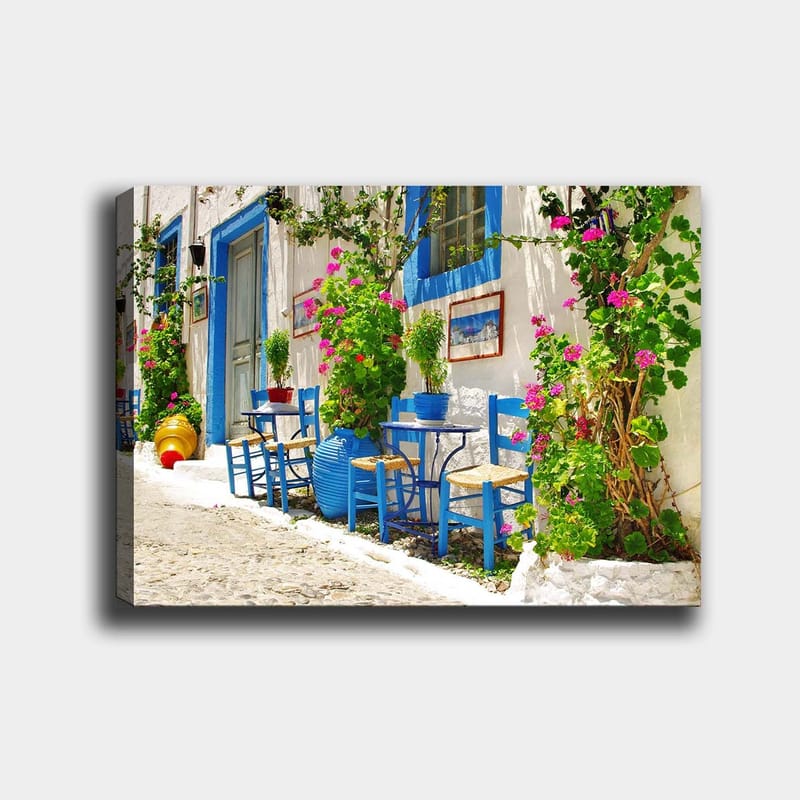 Lærred 70x100 cm - Farverig og livlig gade med blå stole og blomsterkrukker i middelhavsmiljø - Blå / Grøn / Lyserød - Boligtilbehør - Billeder & kunst - Billeder på lærred