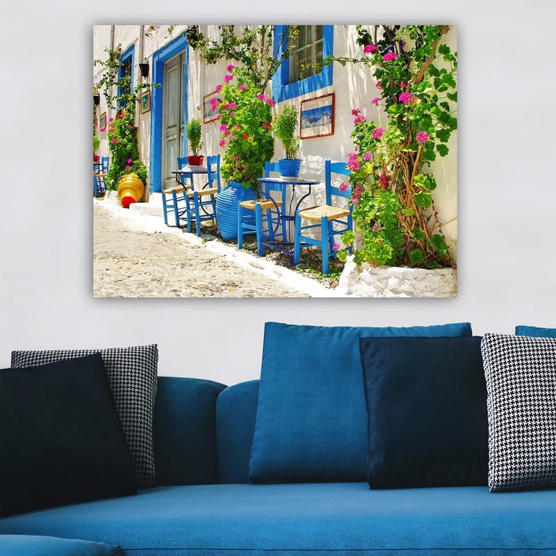 Lærred 70x100 cm - Farverig og livlig gade med blå stole og blomsterkrukker i middelhavsmiljø - Blå / Grøn / Lyserød - Boligtilbehør - Billeder & kunst - Billeder på lærred