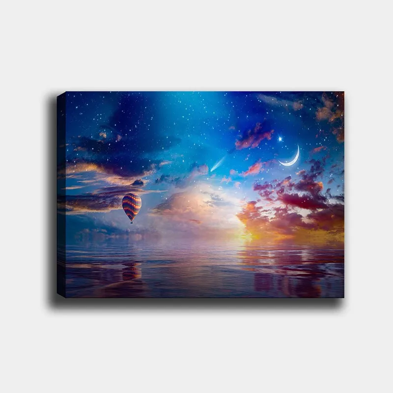 Lærred 70x100 cm - Farverig varmluftballon svæver over en spejlblank overflade under en stjerneklar himmel med dramatiske skyer og en måne, Blå / Orange / Rød