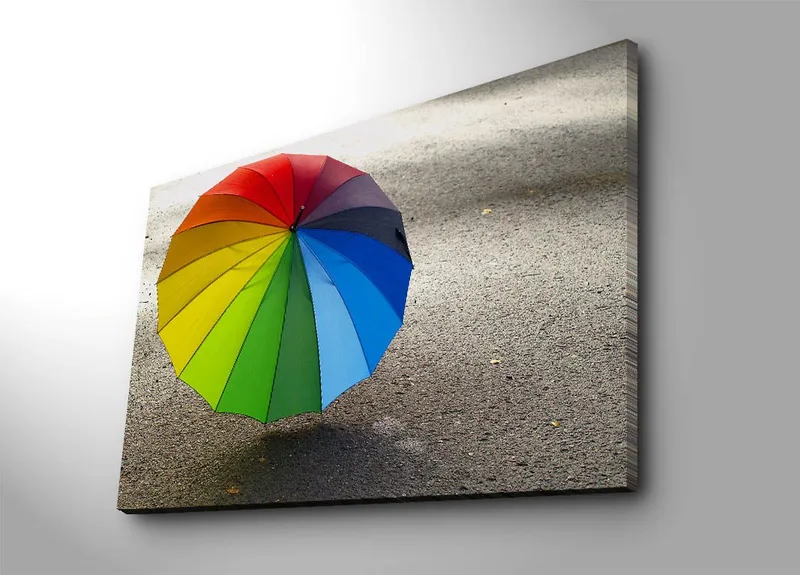 Lærred 70x100 cm - Farverig paraply stående på en grå overflade, Rød / Grøn / Blå