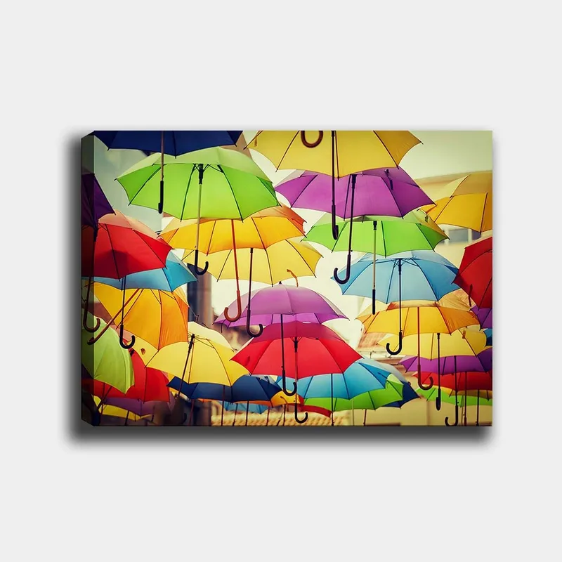 Lærred 70x100 cm - Farverige paraplyer, der hænger i luften, skaber en livlig og legende atmosfære, Grøn / Gul / Rød