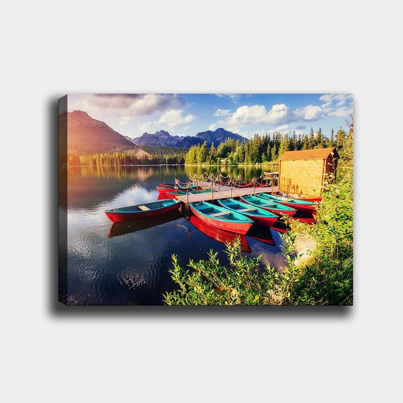 Lærred 70x100 cm - Flere farverige både ligger på en spejlblank sø omgivet af frodige træer og bjerge, Rød / Turkis / Grøn