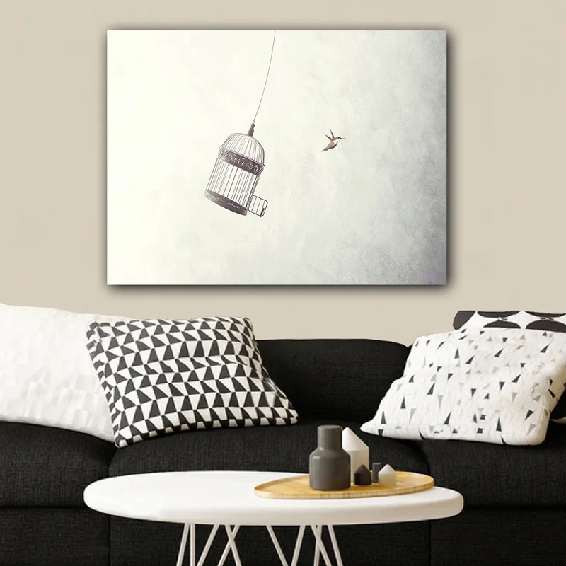 Lærred 70x100 cm - Fuglebur hængende i luften med en fugl der flyver i nærheden - Grå / Sort / Hvid - Boligtilbehør - Billeder & kunst - Billeder på lærred