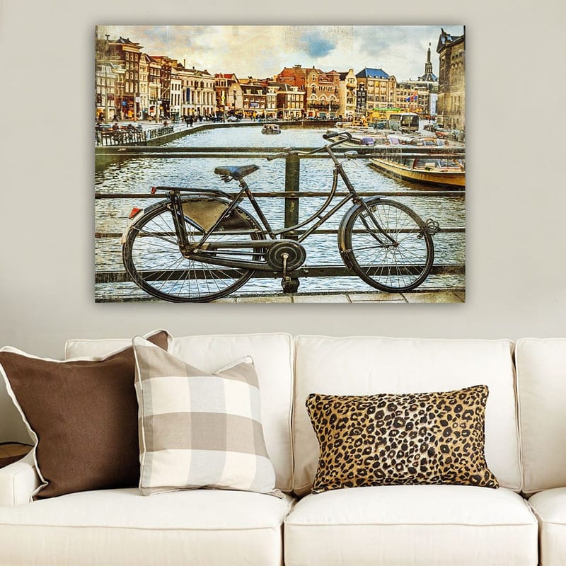 Lærred 70x100 cm - Gammel cykel lænet op ad et rækværk ved en kanal med maleriske bygninger i baggrunden - Sort / Grå / Brun - Boligtilbehør - Billeder & kunst - Billeder på lærred