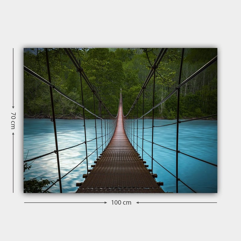 Lærred 70x100 cm - Hængebro over en rolig, blå flod omgivet af frodige træer - Mørkebrun / Turkis / Grøn - Boligtilbehør - Billeder & kunst - Billeder på lærred
