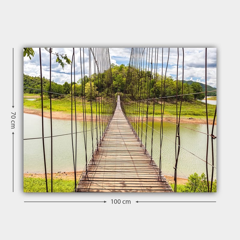 Lærred 70x100 cm - Hængebro over en rolig sø, omgivet af frodigt grønt - Grøn / Brun / Blå - Boligtilbehør - Billeder & kunst - Billeder på lærred