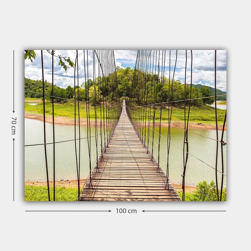 Lærred 70x100 cm - Hængebro over en rolig sø, omgivet af frodigt grønt - Grøn / Brun / Blå - Boligtilbehør - Billeder & kunst - Billeder på lærred