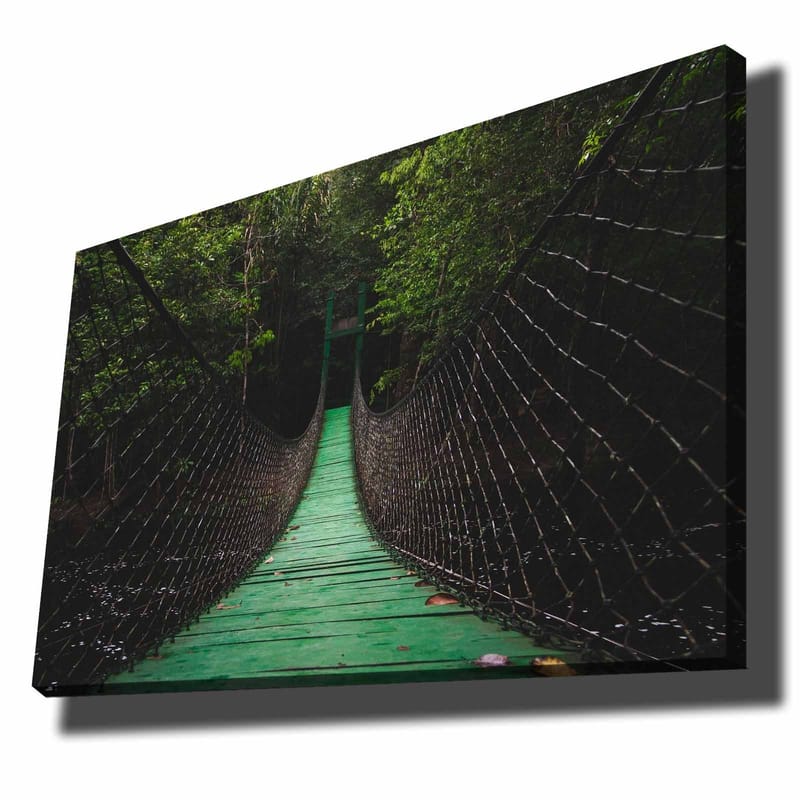 Lærred 70x100 cm - Hængebro strækker sig gennem en frodig skov, Grøn / Sort