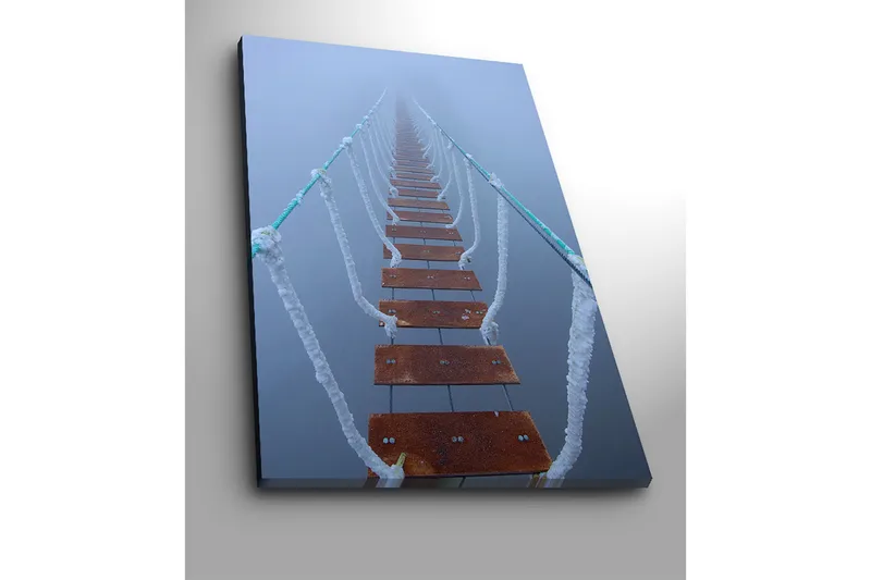 Lærred 70x100 cm - Hængebro strækker sig gennem tågen og skaber en mystisk og fjern følelse - Mørkebrun / Hvid / Lyseblå - Boligtilbehør - Billeder & kunst - Billeder på lærred