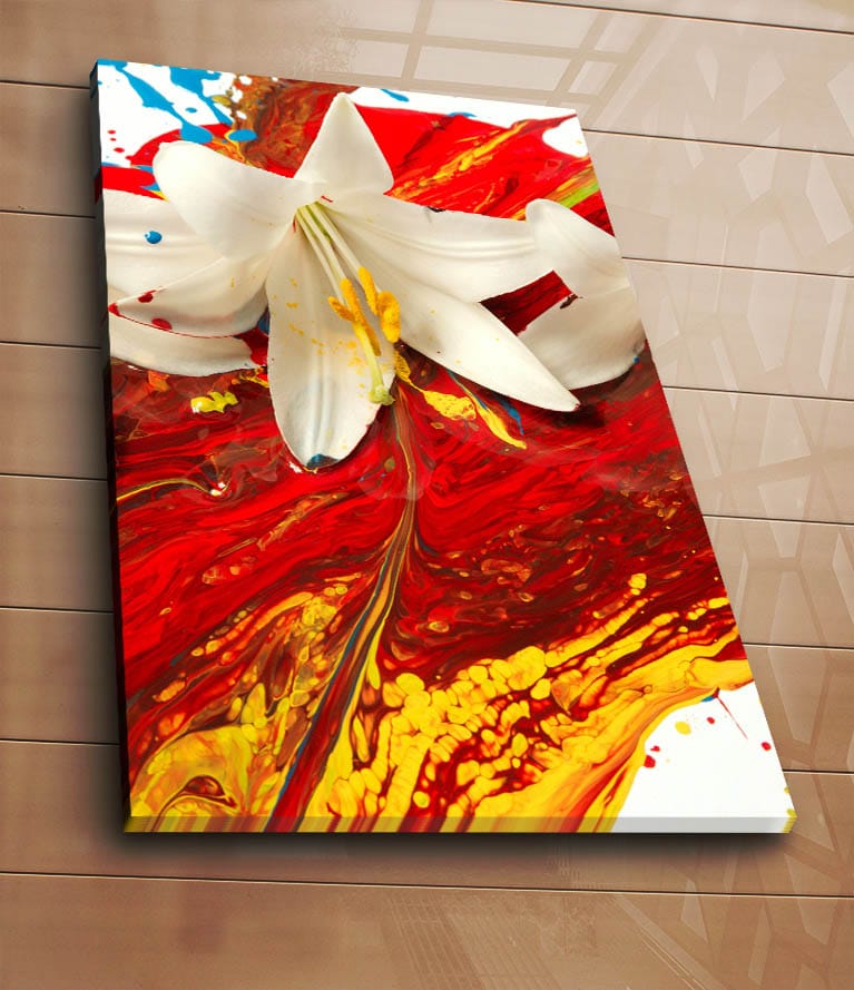Lærred 70x100 cm - Hvid lilje, der står tydeligt frem mod en baggrund af intense røde og gule farver - Rød / Gul / Hvid - Boligtilbehør - Billeder & kunst - Billeder på lærred