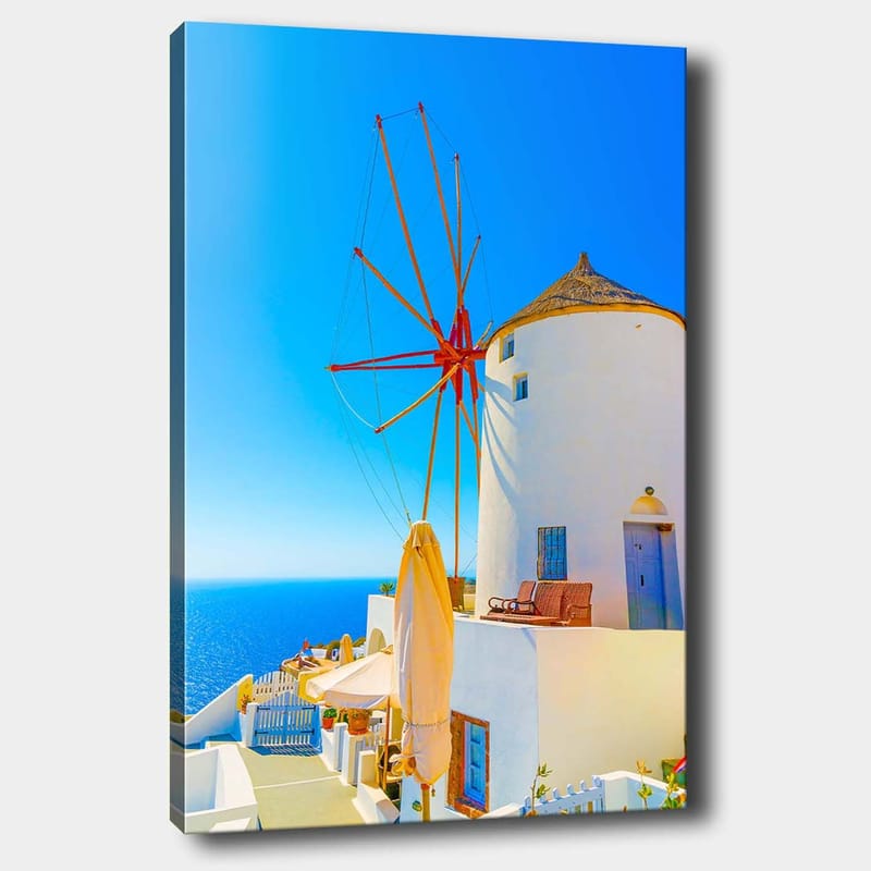 Lærred 70x100 cm - Hvid vindmølle med rød rotor på en klippe ved havet, omgivet af klar blå himmel og hav - Hvid / Rød / Blå - Boligtilbehør - Billeder & kunst - Billeder på lærred