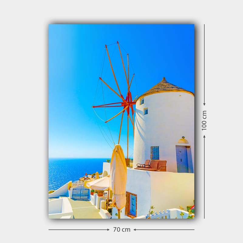 Lærred 70x100 cm - Hvid vindmølle med rød rotor på en klippe ved havet, omgivet af klar blå himmel og hav - Hvid / Rød / Blå - Boligtilbehør - Billeder & kunst - Billeder på lærred