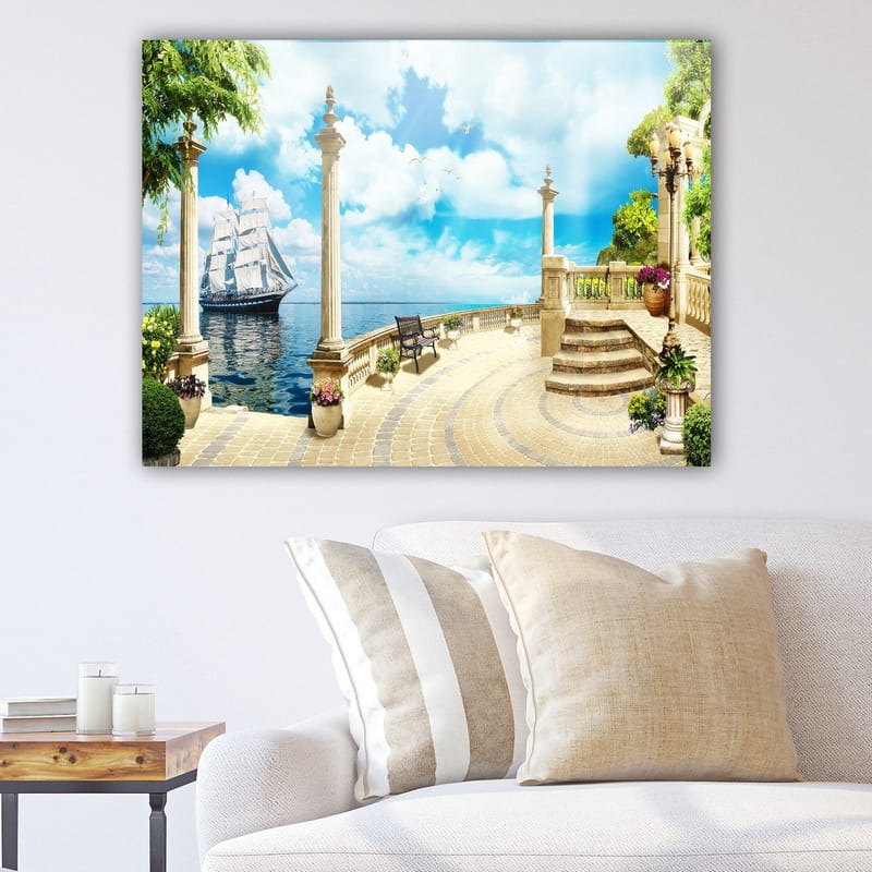 Lærred 70x100 cm - Idyllisk havudsigt med en sejlbåd, omgivet af søjler og grønne områder, Blå / Grøn / Beige