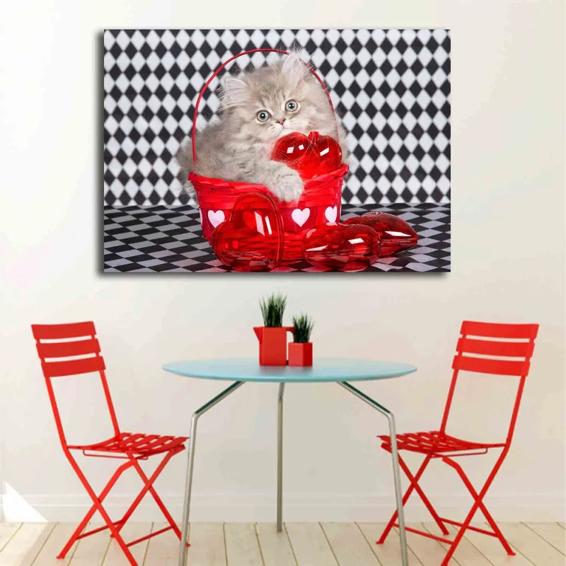 Lærred 70x100 cm - Killing sidder i en rød kurv fyldt med hjerteformede dekorationer - Rød / Grå - Boligtilbehør - Billeder & kunst - Billeder på lærred