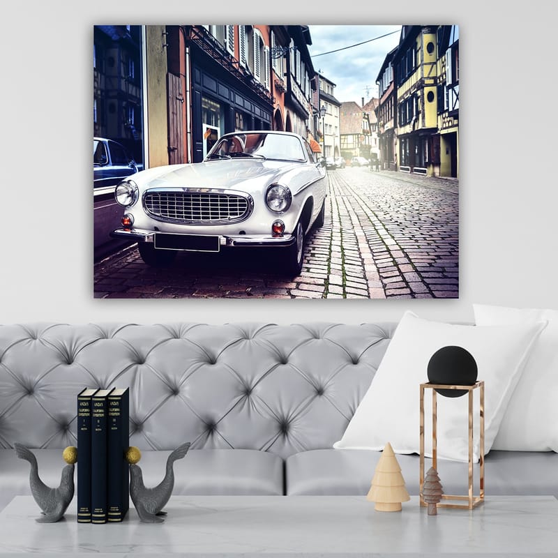Lærred 70x100 cm - Klassisk hvid bil parkeret på en charmerende, gammeldags gade med historiske bygninger - Hvid / Sort / Grå - Boligtilbehør - Billeder & kunst - Billeder på lærred