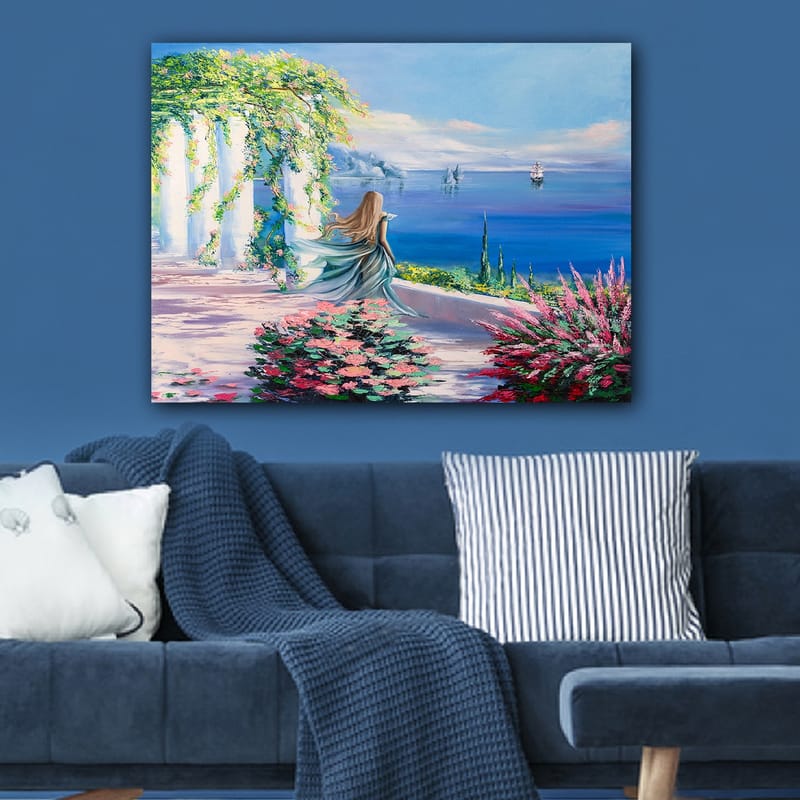 Lærred 70x100 cm - Kvinde i blå kjole stående ved et udsigtspunkt med havet og sejlbåde i baggrunden - Blå / Grøn / Lyserød - Boligtilbehør - Billeder & kunst - Billeder på lærred