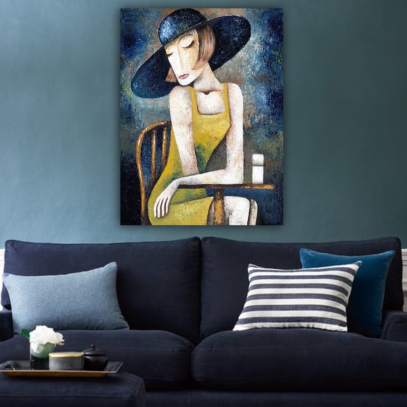 Lærred 70x100 cm - Kvinde i gul kjole siddende ved et bord med en hvid kop, iført en stor sort hat - Gul / Sort / Blågrøn - Boligtilbehør - Billeder & kunst - Billeder på lærred