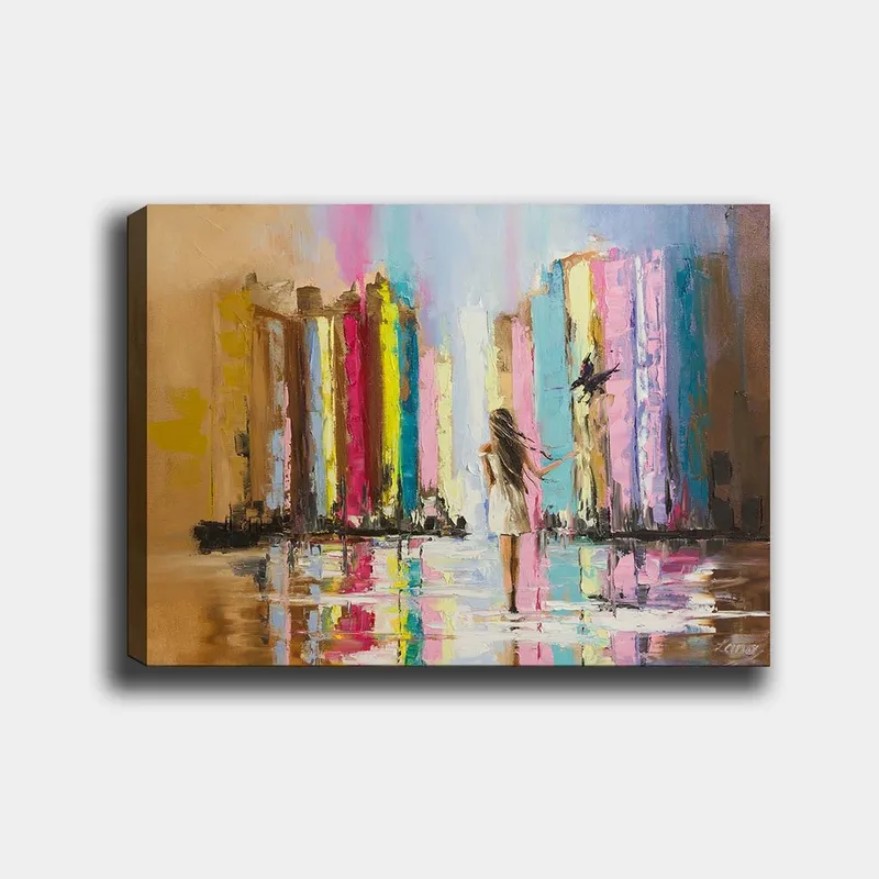 Lærred 70x100 cm - Kvinde i hvid kjole går gennem en farverig by med høje bygninger i baggrunden, Lyserød / Gul / Blå