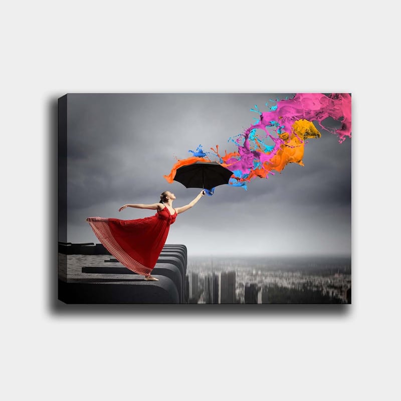 Lærred 70x100 cm - Kvinde i rød kjole står på en kant og holder en paraply, mens farverige malingsstråler sprøjter ud fra den, Rød / Sort / Orange