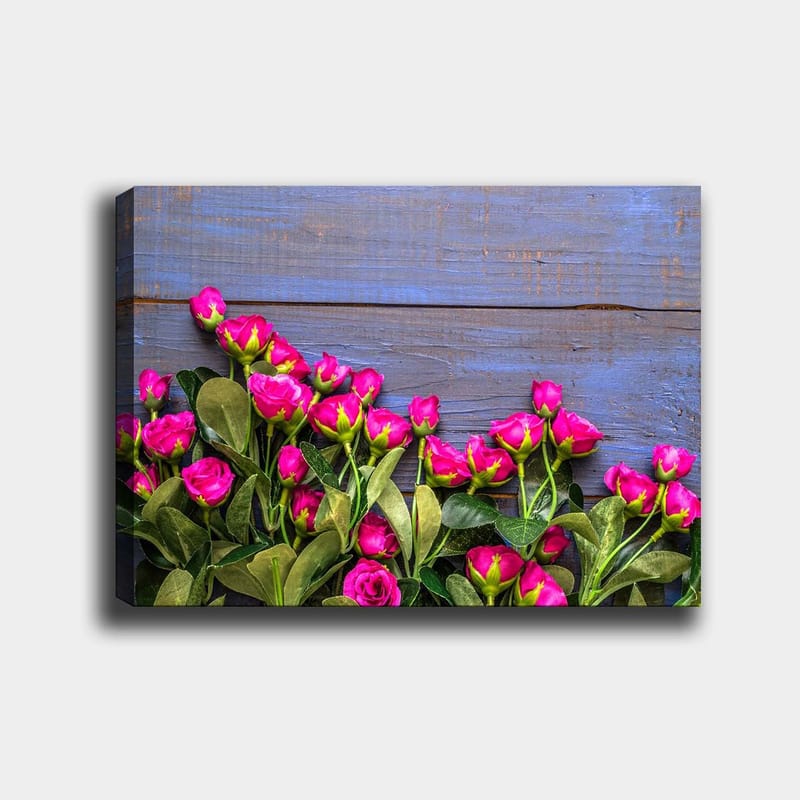 Lærred 70x100 cm - Livlig samling af lyserøde roser mod en blå træbaggrund - Lyserød / Grøn / Blå - Boligtilbehør - Billeder & kunst - Billeder på lærred