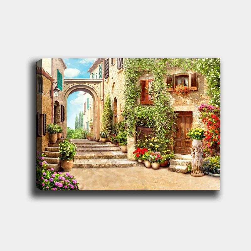 Lærred 70x100 cm - Malerisk gade med blomster og grønne områder i charmerende landsbyomgivelser - Grøn / Gul / Lyserød - Boligtilbehør - Billeder & kunst - Billeder på lærred