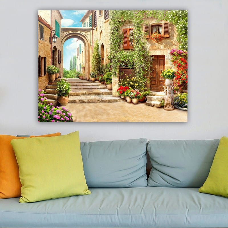 Lærred 70x100 cm - Malerisk gade med blomster og grønne områder i charmerende landsbyomgivelser - Grøn / Gul / Lyserød - Boligtilbehør - Billeder & kunst - Billeder på lærred