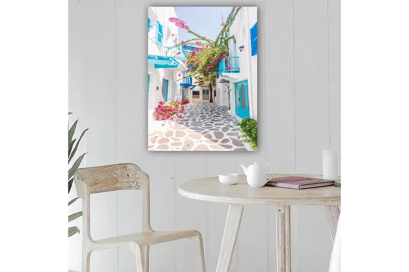 Lærred 70x100 cm - Malerisk gyde med hvide huse og farverige blomster i middelhavsmiljø - Blå / Lyserød / Hvid - Boligtilbehør - Billeder & kunst - Billeder på lærred