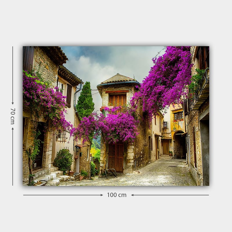 Lærred 70x100 cm - Malerisk gyde omgivet af farverige blomster i charmerende landsbyomgivelser - Lilla / Grøn / Beige - Boligtilbehør - Billeder & kunst - Billeder på lærred