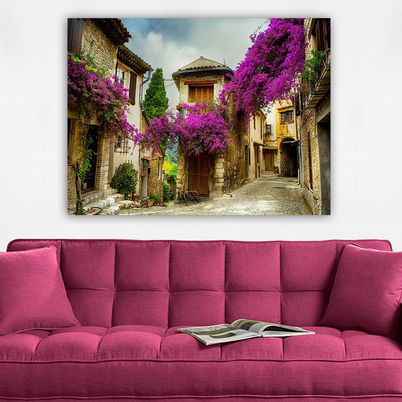 Lærred 70x100 cm - Malerisk gyde omgivet af farverige blomster i charmerende landsbyomgivelser - Lilla / Grøn / Beige - Boligtilbehør - Billeder & kunst - Billeder på lærred