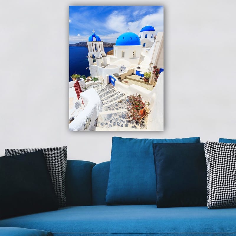 Lærred 70x100 cm - Malerisk udsigt over hvide huse med blå kupler og en asfalteret vej i en græsk ø-omgivelse - Blå / Hvid - Boligtilbehør - Billeder & kunst - Billeder på lærred