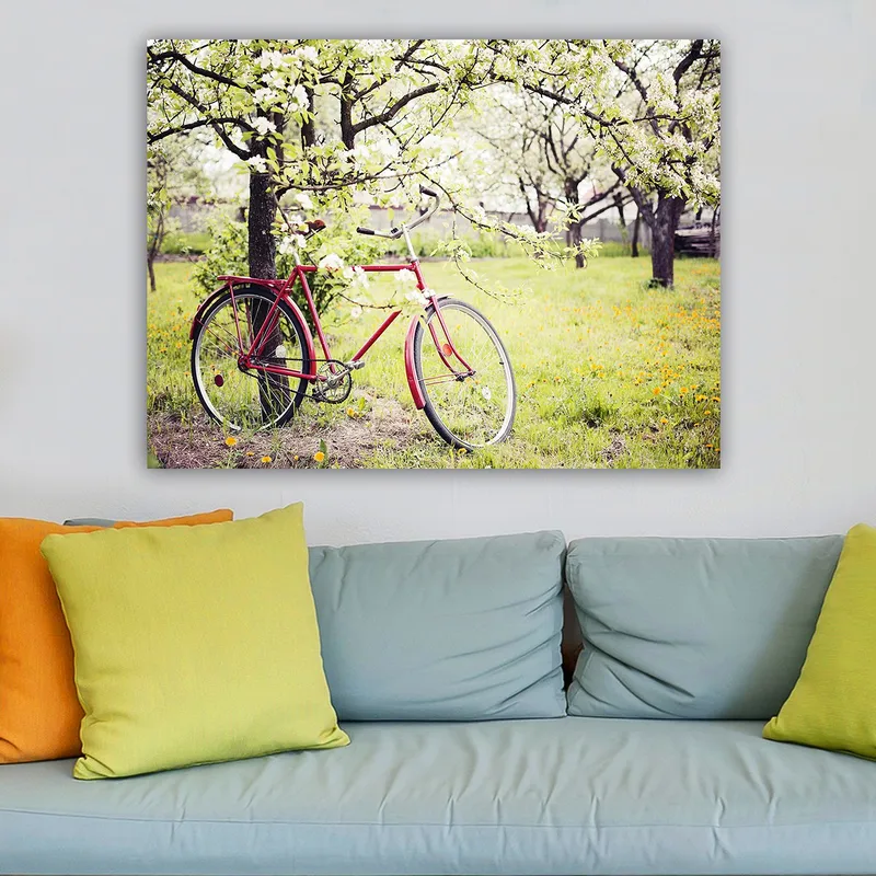 Lærred 70x100 cm - Rød cykel stående under blomstrende træer i et frodigt miljø - Rød / Grøn / Hvid - Boligtilbehør - Billeder & kunst - Billeder på lærred