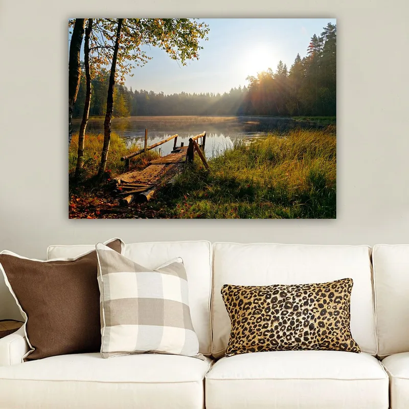 Lærred 70x100 cm - Rolig sø med en træbro omgivet af frodige træer og morgensolens stråler - Grøn / Brun / Gul - Boligtilbehør - Billeder & kunst - Billeder på lærred