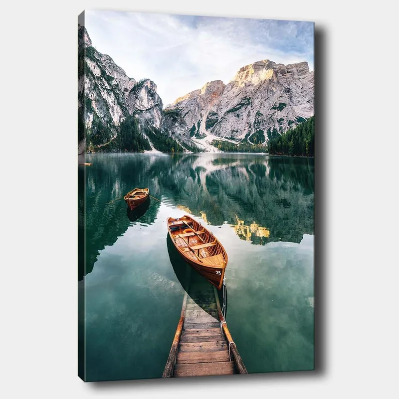 Lærred 70x100 cm - Rolig sø med to træbåde omgivet af majestætiske bjerge og frodig skov, Grøn / Brun / Blå