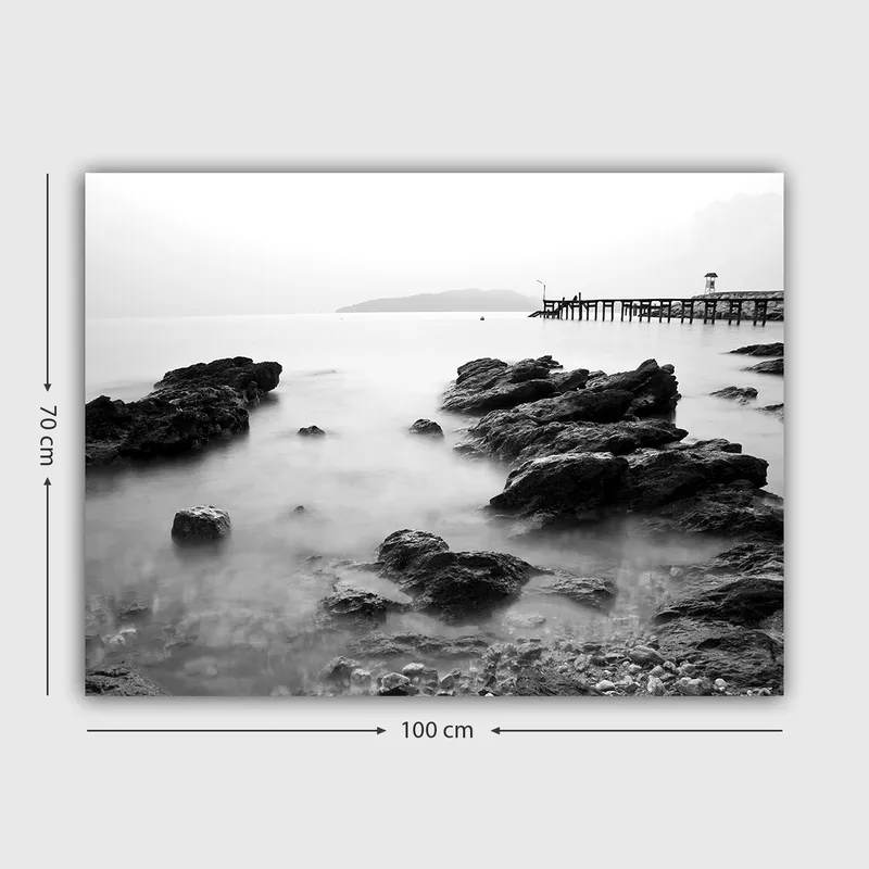 Lærred 70x100 cm - Roligt kystlandskab med klipper og en mole i det fjerne - Sort / Hvid / Grå - Boligtilbehør - Billeder & kunst - Billeder på lærred