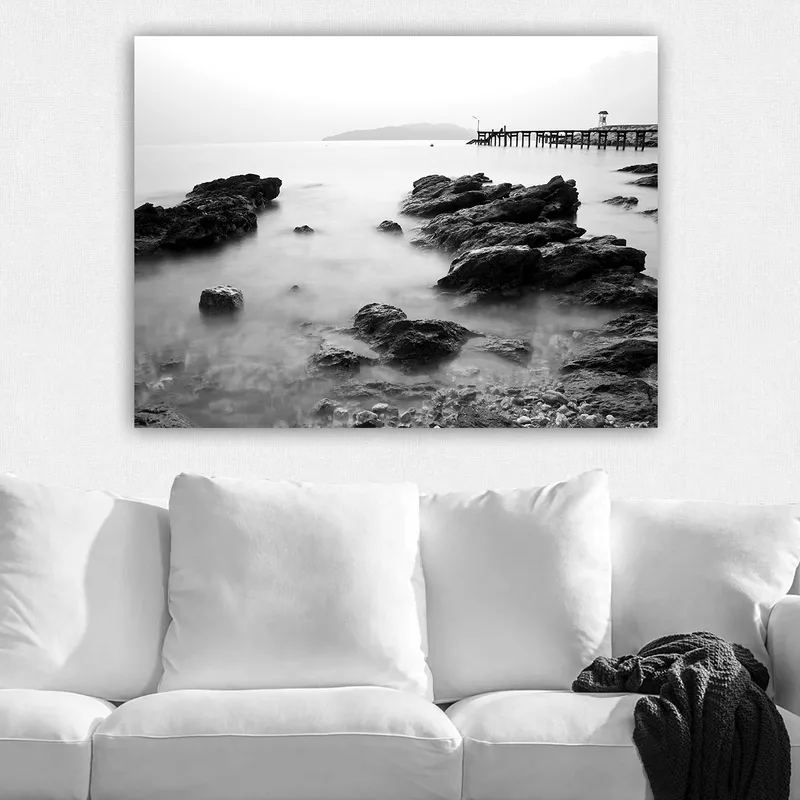 Lærred 70x100 cm - Roligt kystlandskab med klipper og en mole i det fjerne - Sort / Hvid / Grå - Boligtilbehør - Billeder & kunst - Billeder på lærred