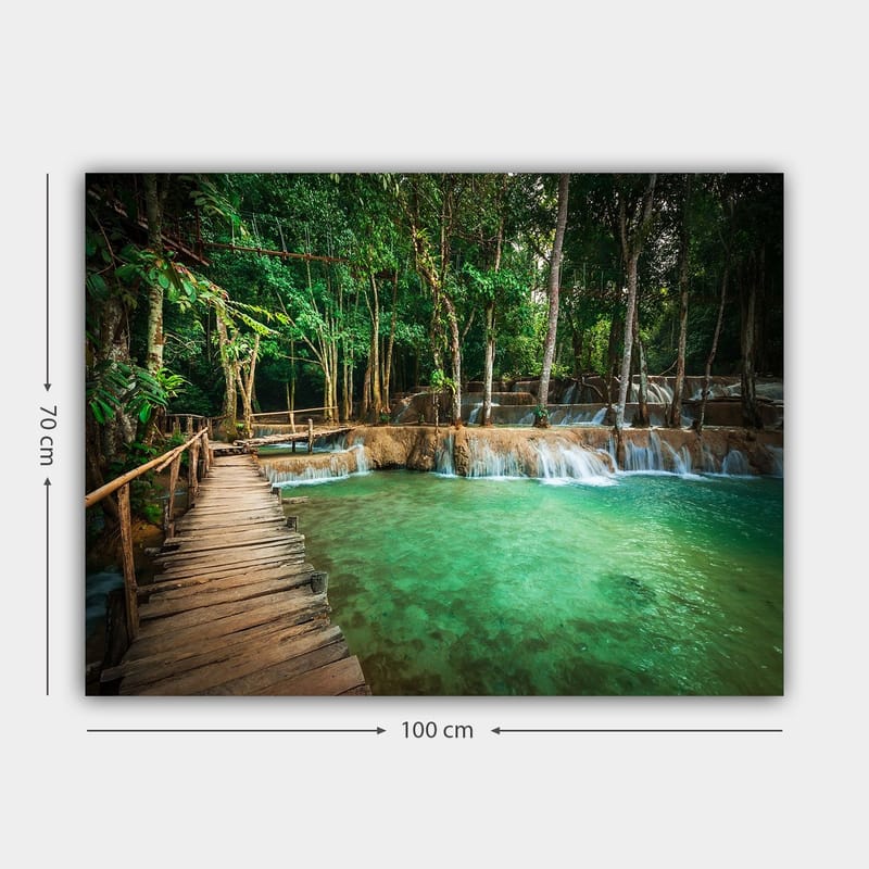 Lærred 70x100 cm - Roligt og naturskønt sted med en træbro, der fører over en klar, turkis vandfaldspool omgivet af frodigt grønt - Turkis / Grøn / Brun - Boligtilbehør - Billeder & kunst - Billeder på lærred