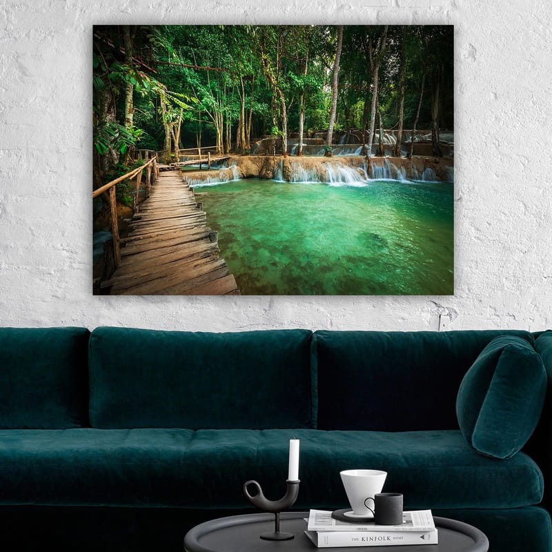 Lærred 70x100 cm - Roligt og naturskønt sted med en træbro, der fører over en klar, turkis vandfaldspool omgivet af frodigt grønt - Turkis / Grøn / Brun - Boligtilbehør - Billeder & kunst - Billeder på lærred