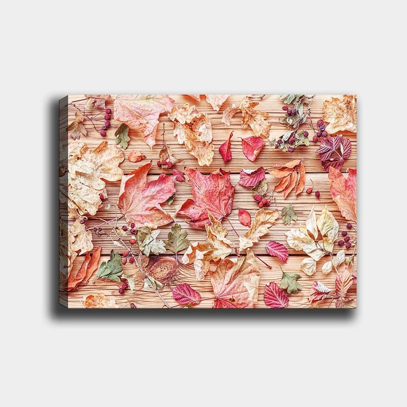 Lærred 70x100 cm - Samling af efterårsblade i forskellige farver liggende på en træoverflade - Rød / Gul / Grøn - Boligtilbehør - Billeder & kunst - Billeder på lærred