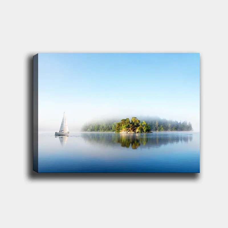Lærred 70x100 cm - Sejlbåd glider hen over en spejlblank sø med en tåget ø i baggrunden, Blå / Grøn / Hvid