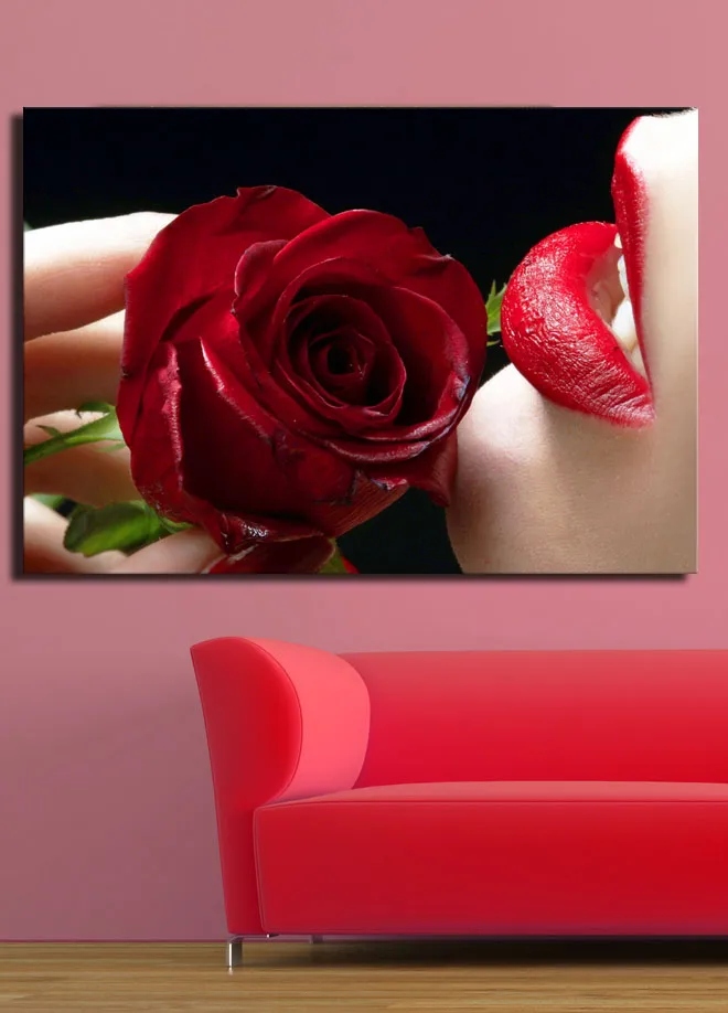 Lærred 70x100 cm - Sensuel nærbillede af en rose holdt tæt på en læbe med rød læbestift - Rød / Grøn - Boligtilbehør - Billeder & kunst - Billeder på lærred