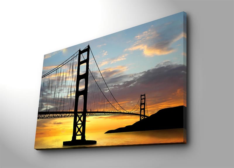 Lærred 70x100 cm - Silhuet af en bro mod en farverig solnedgang, Orange / Sort / Blå